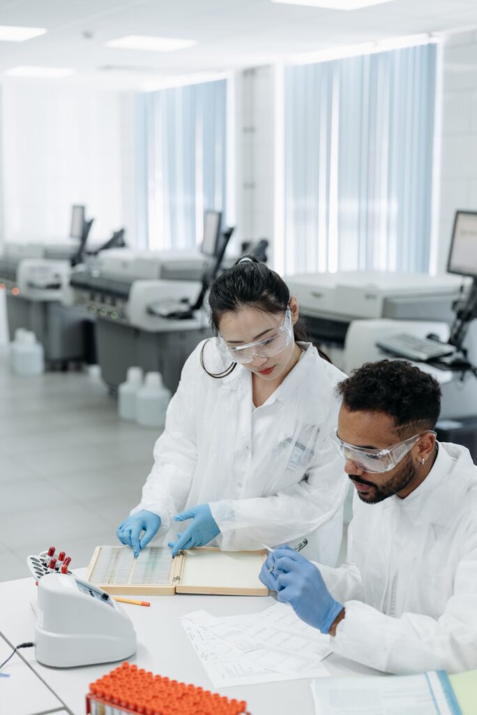 Centros de estudio de longevidad (Parte 3/3) Dos investigadores de distintas etnias trabajando juntos con muestras en un laboratorio de investigación