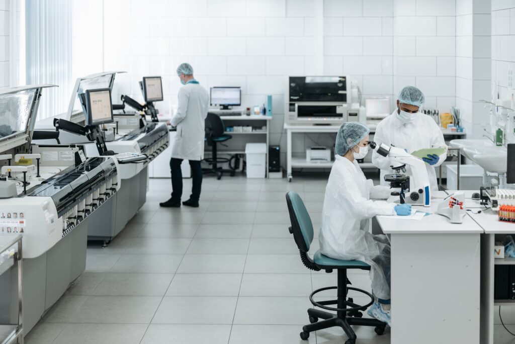 Centros de estudio de longevidad (Parte 2/3) Equipo de investigadores con guardapolvo trabajando en distintas estaciones de un laboratorio científico